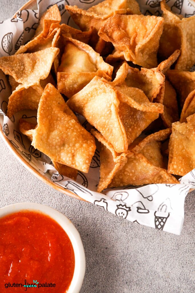 Gluten-Free Crab Rangoon in a wooden bowl with a dipping sauce.