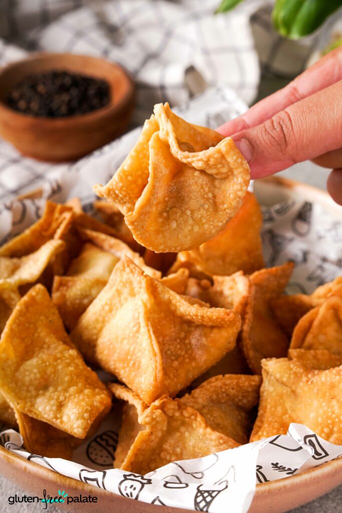 Gluten-Free Crab Rangoon being held so show the texture.