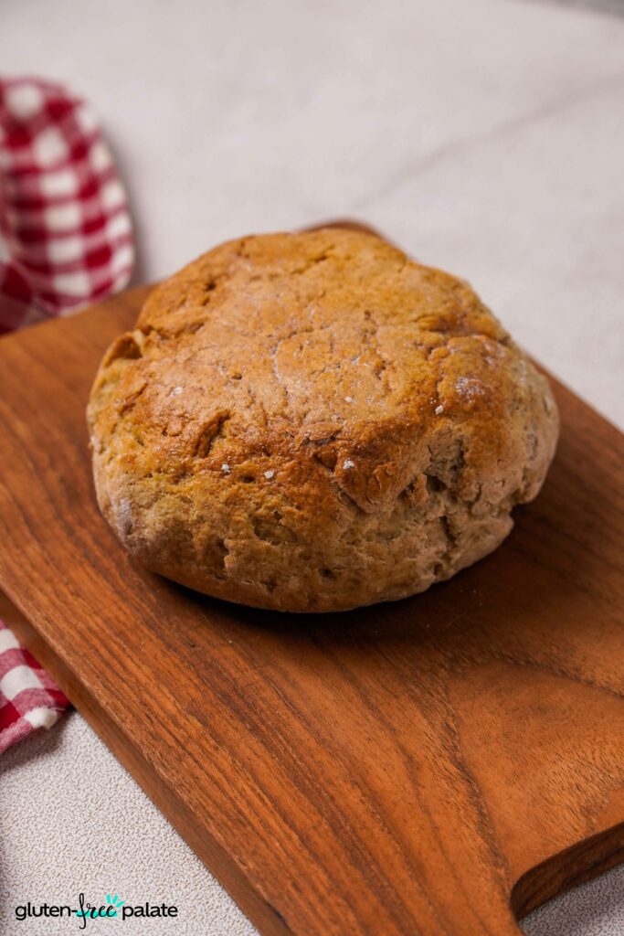 Gluten-free Artisan bread unsliced on a bread board.