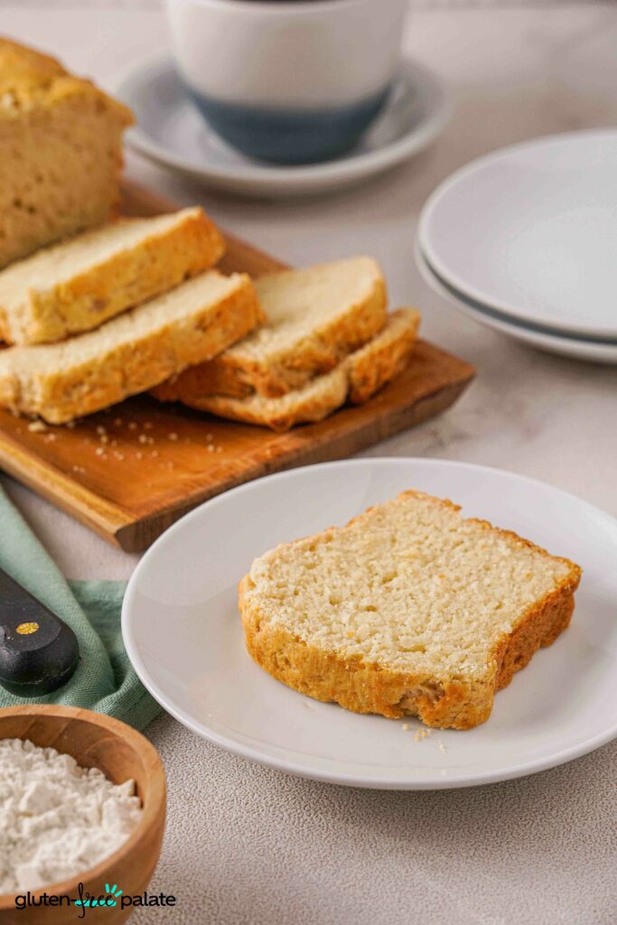 Close up view of A slice of Gluten-Free Brioche in a plate and slices in a bread board.