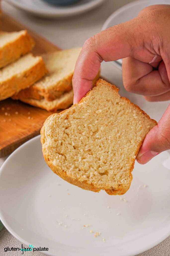 Gluten-Free Brioche being held by fingers showing the texture.
