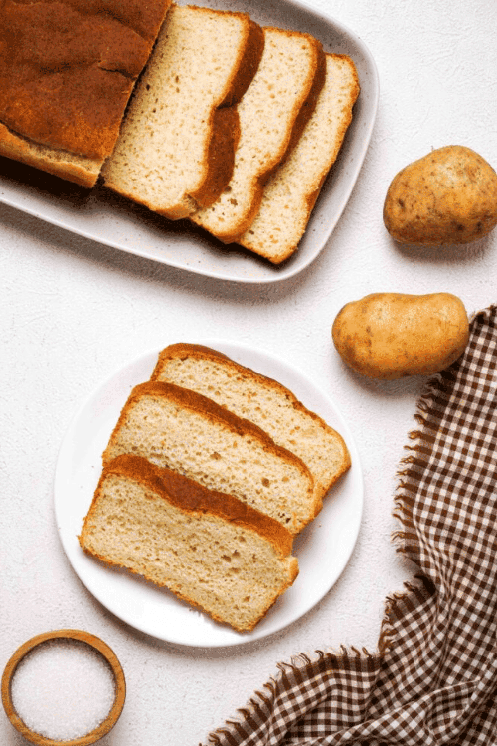 Three slices of gluten-free potato bread on a plate next to a loaf.
