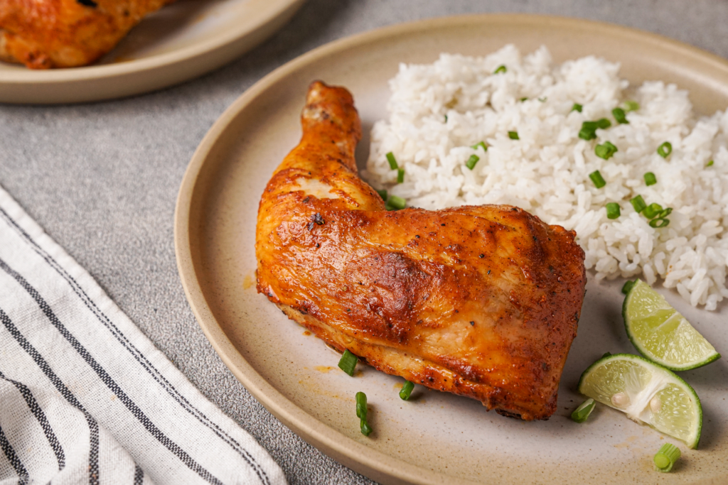 A plate of tandoori chicken with white rice, ready to eat.
