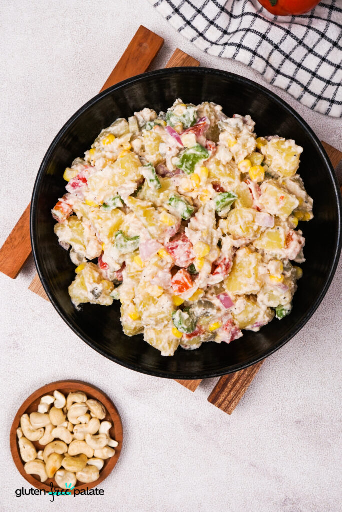 Top-down view of the vegan potato salad in a black bowl, with vibrant veggies and a creamy cashew dressing. Photo by Gluten-Free Palate.