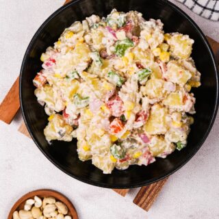 Top-down view of the vegan potato salad in a black bowl, with vibrant veggies and a creamy cashew dressing. Photo by Gluten-Free Palate.