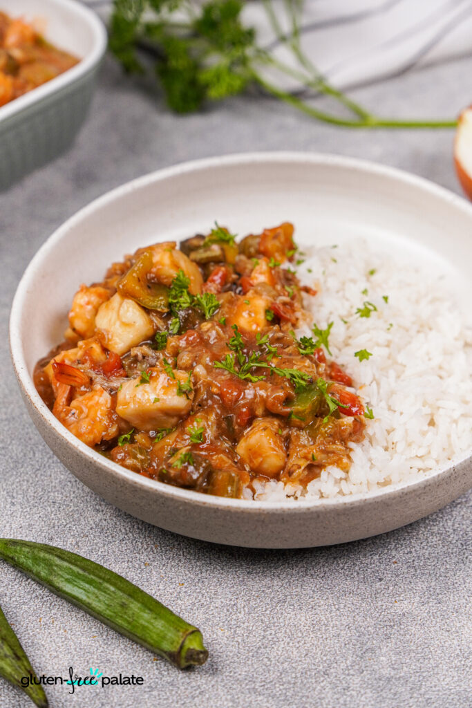Gluten-free seafood gumbo in a white bowl with rice. Photo by Gluten-Free Palate.