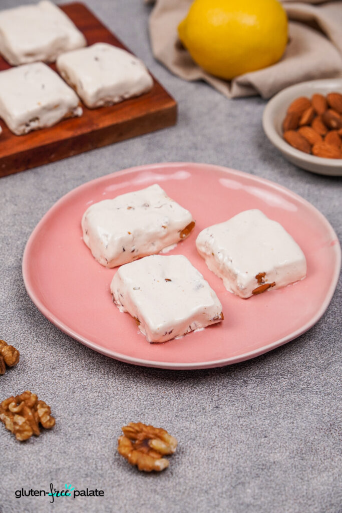 A side angle of 3 pieces of gluten-free nougat on a plate.