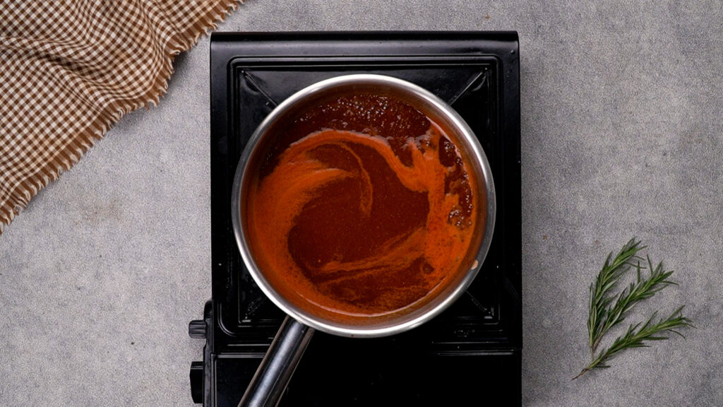 Step 3 BBQ sauce simmering in a saucepan.
