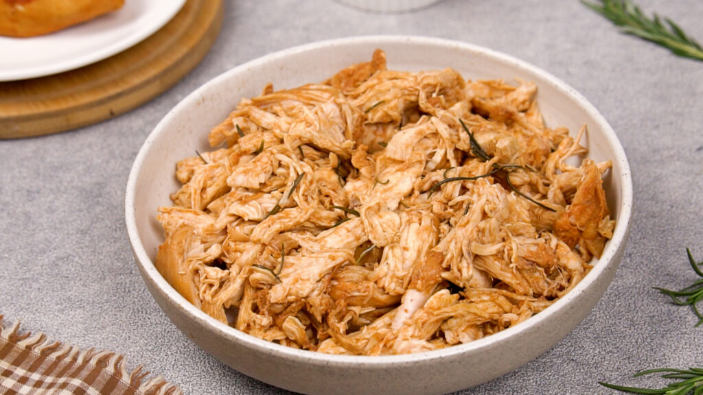 Step 8 A bowl of shredded barbecue chicken, tender and juicy, with rosemary.