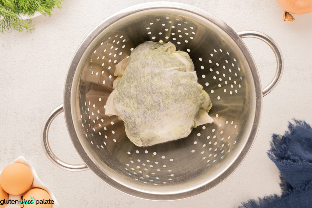 Spinach being drained with cheesecloth and a colander.