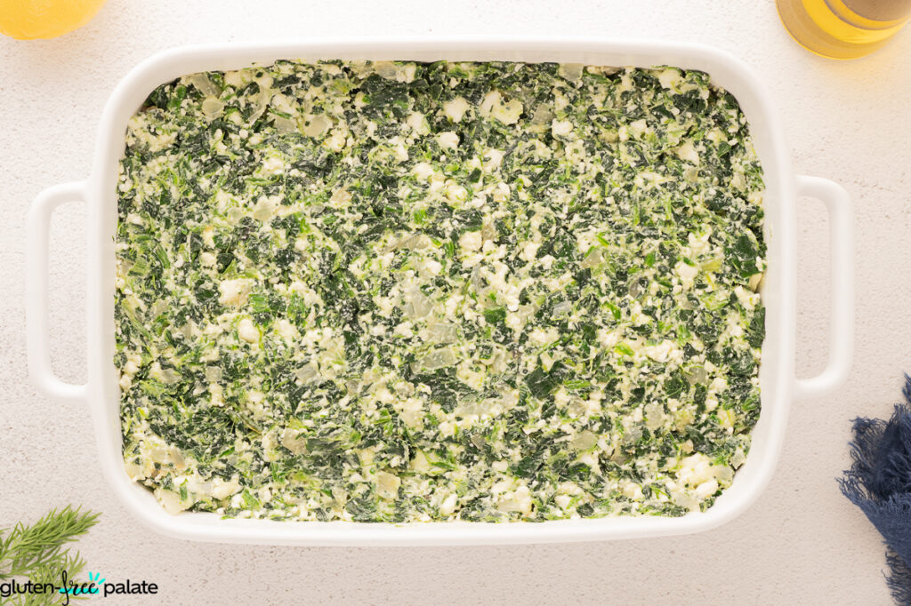 The filling being added into the casserole dish.