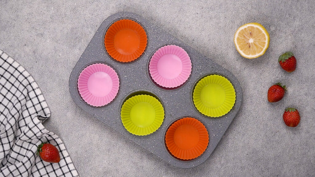 A muffin tin lined with colorful silicone baking cups.