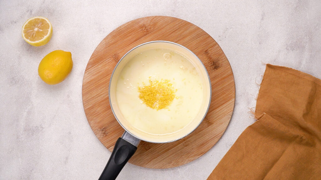 Lemon zest added to the saucepan for a thickened cream mixture.