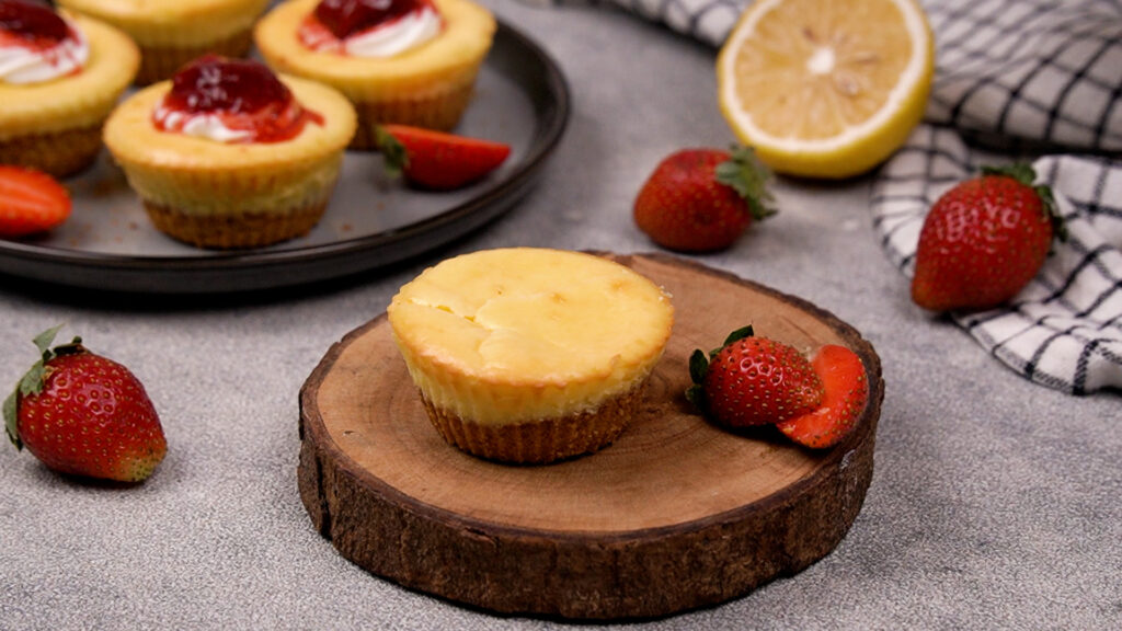 A freshly baked gluten-free mini cheesecake cooling on a wooden board.