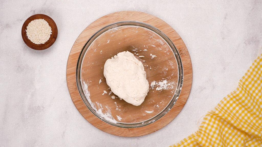 A ball of gluten-free cracker dough has formed in the mixing bowl, ready to be rolled out and shaped.