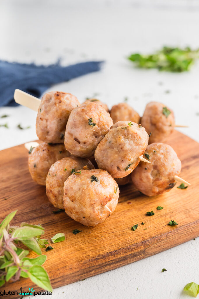 Meatballs on skewers on a wooden board.
