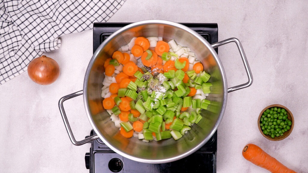 Chopped carrots, celery, and onions added to a new pot.