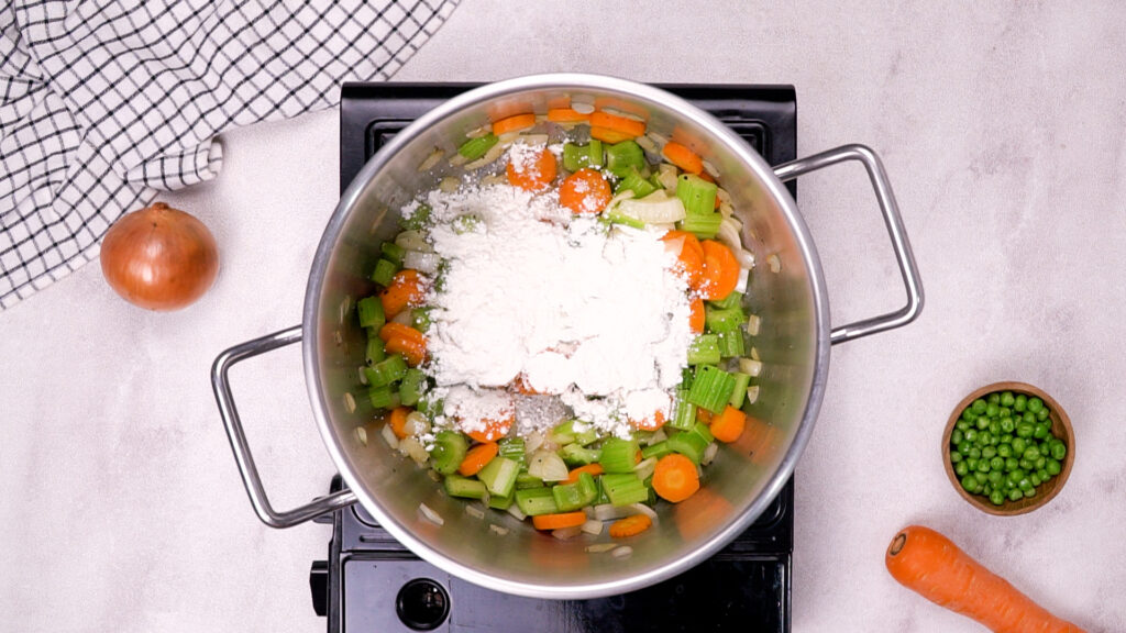 Chicken soup base with milk and green peas added to the pot.