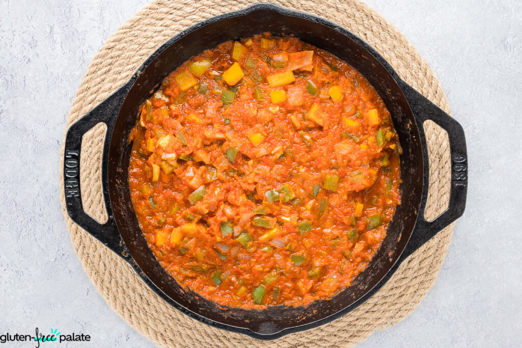 Gluten-free bell pepper salsa cooking in a cast iron skillet.