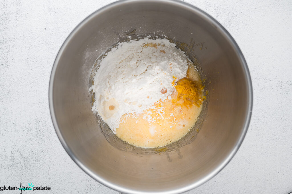 Dry ingredients, and wet ingredients added together in a stainless-steel mixing bowl, ready to mix.