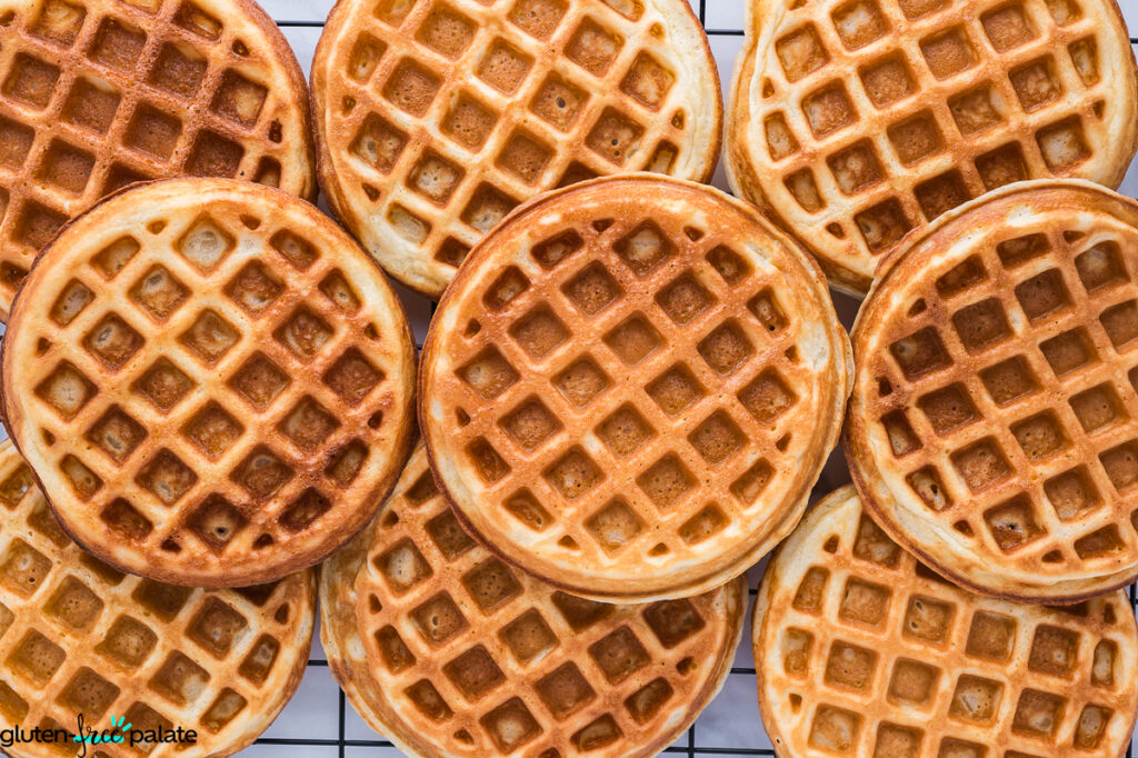 Overhead view of freshly cooked gluten-free mochi waffles cooling on a wire rack.
