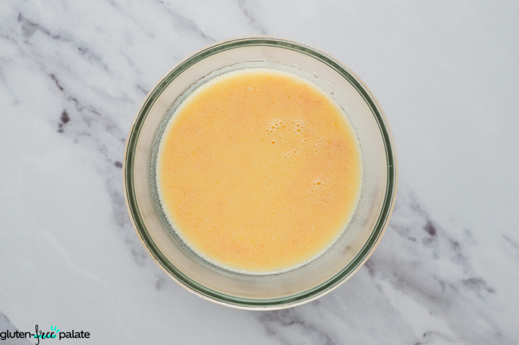 Bowl with beaten egg yolks, milk, butter, and vanilla mixed together for the wet base.