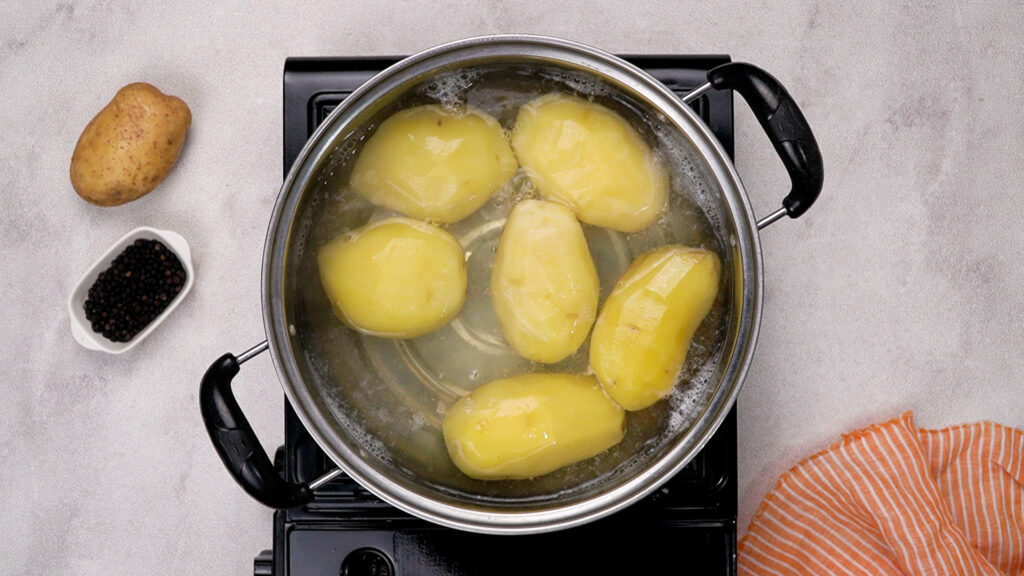 Yukon gold potatoes boiling in a pot of water.