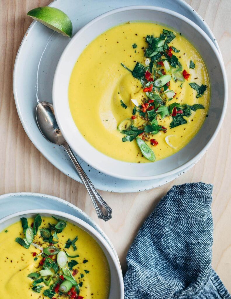 Cauliflower turmeric soup in bowls being served. Photo by brooklynsupper.com.