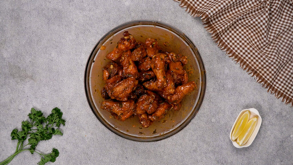 The fried chicken wings fully coated and tossed in cowboy butter sauce, glistening and seasoned.