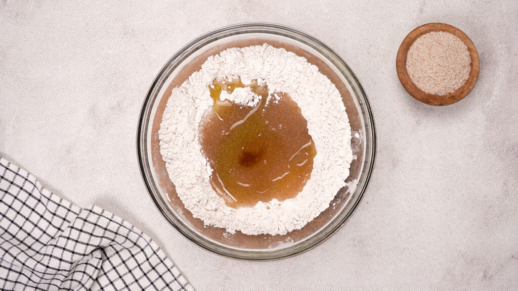 Mixing bowl with gluten-free flours and added psyllium gel, olive oil, and apple cider vinegar in the center.