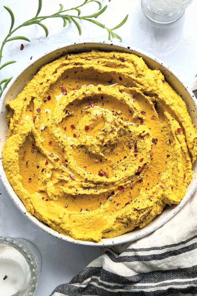 Turmeric Hummus Recipe with Black Pepper in a white bowl. Photo by theherbeevore.com.