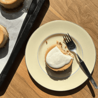 A plate with a fork and a gluten-free cheesecake bite on it.