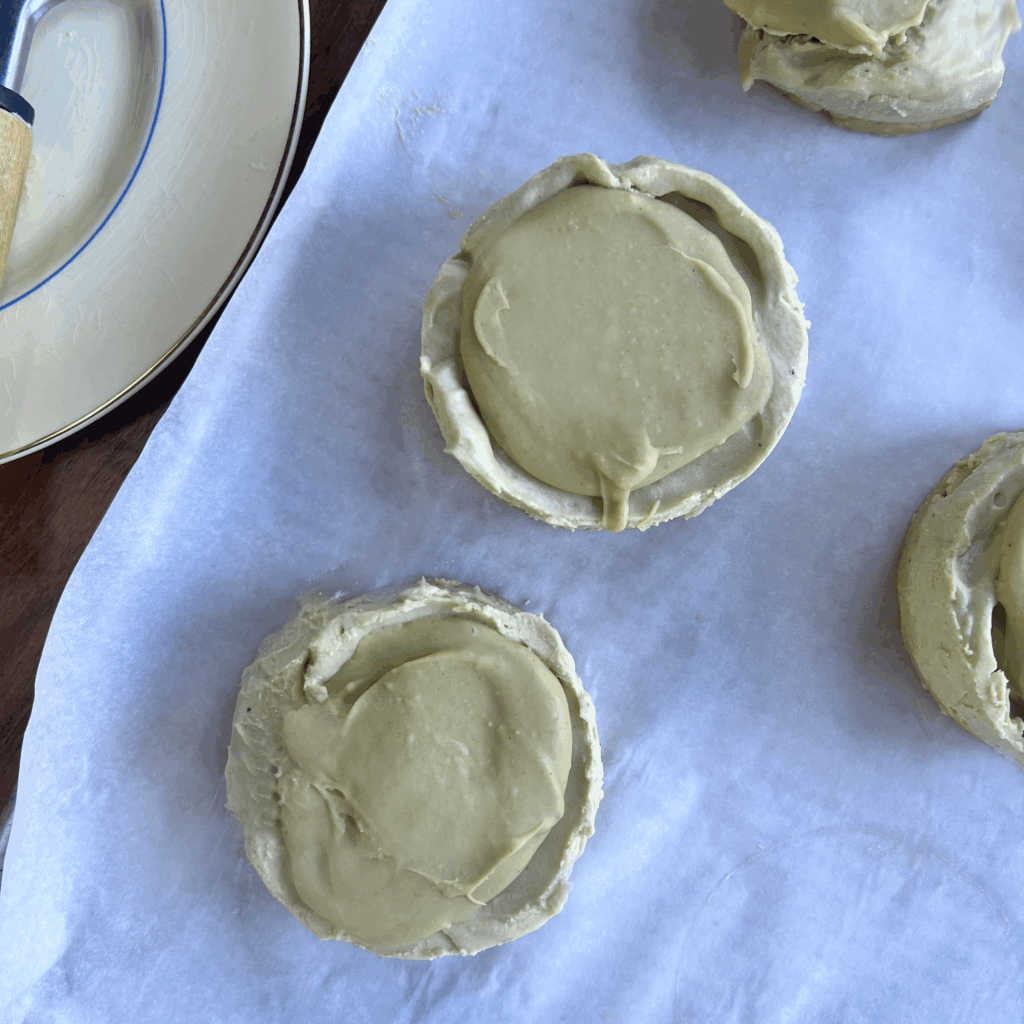 Two mini cheesecakes with pistachio topping, shown from above without professional lighting.