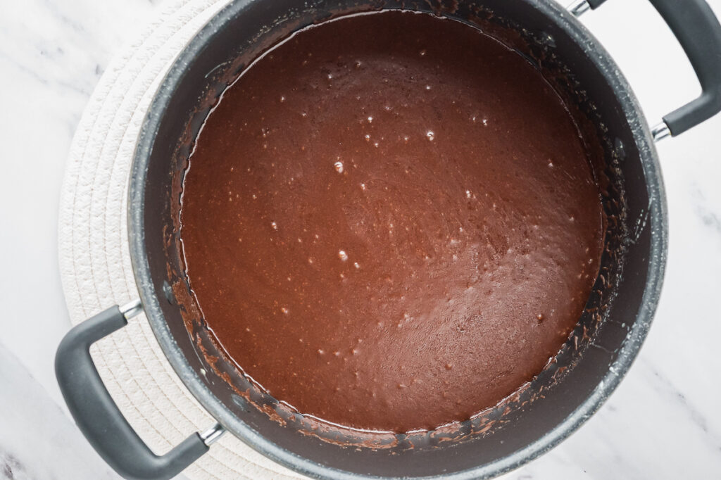 Placing chocolate in fudge mixture.