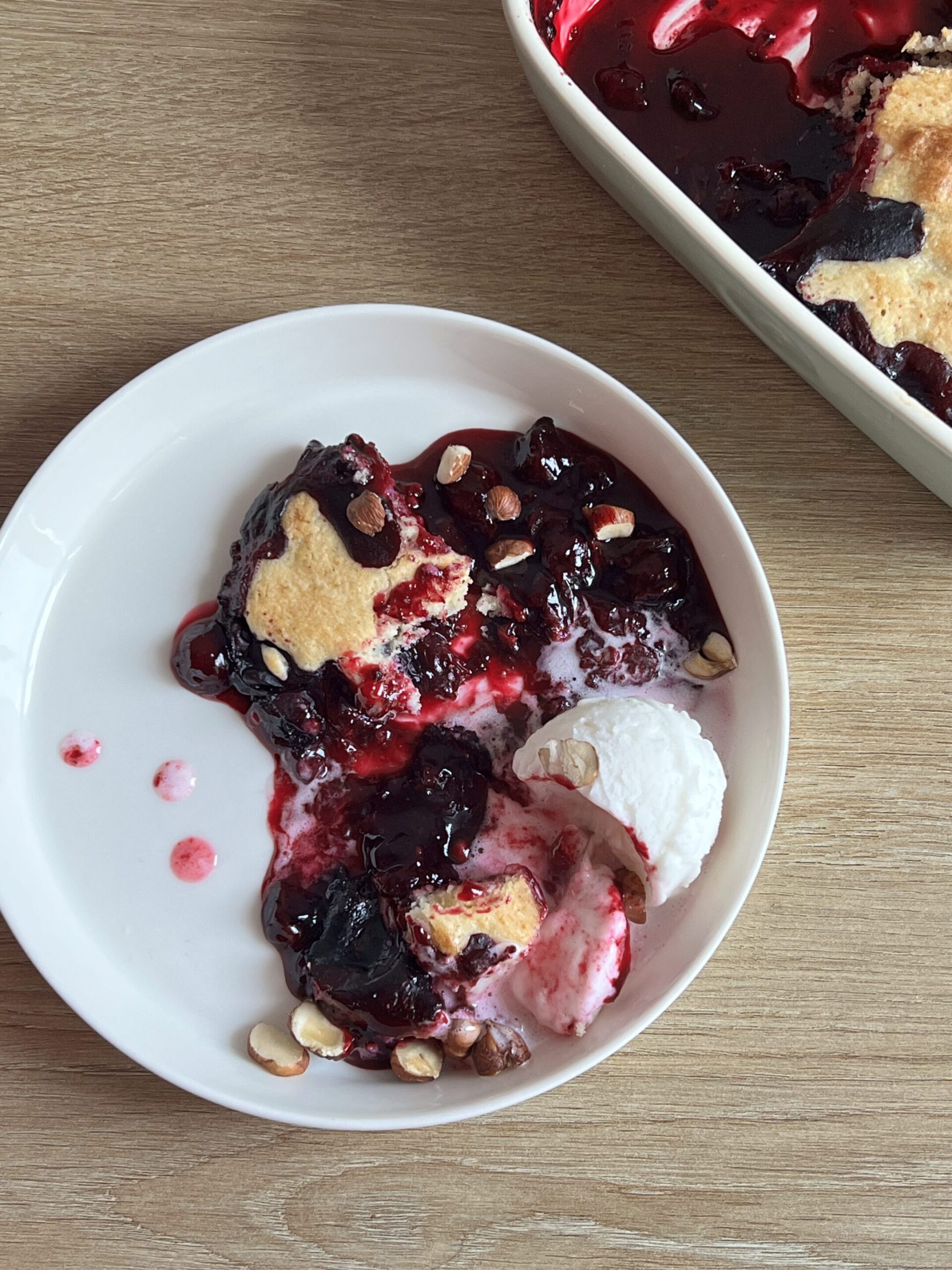 Blueberry cobbler dished onto on a white plate.