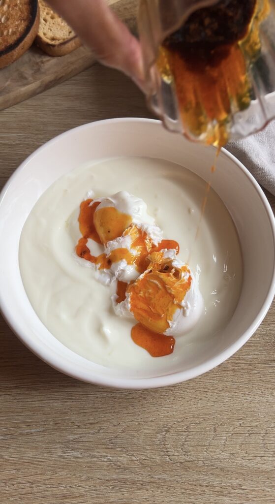 Pouring Chili Butter over Turkish Eggs.