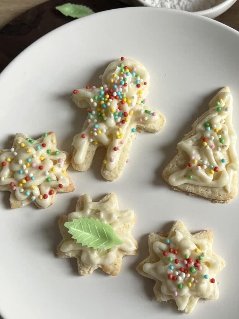 A plate of Christmas Sugar Cookies cut in different shapes.