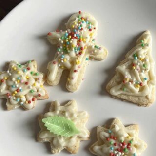 A plate of Christmas Sugar Cookies cut in different shapes.