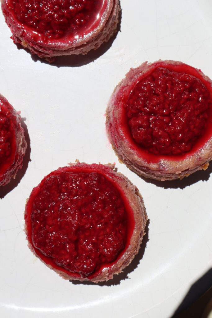 Multiple mini raspberry cheesecakes.
