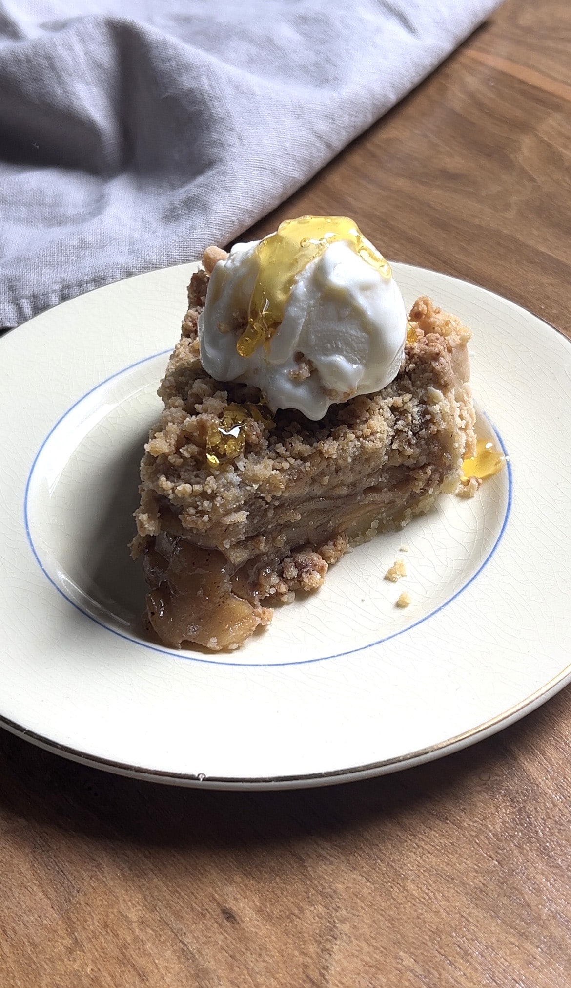 Slice of gluten-free apple crumb pie served with ice cream.