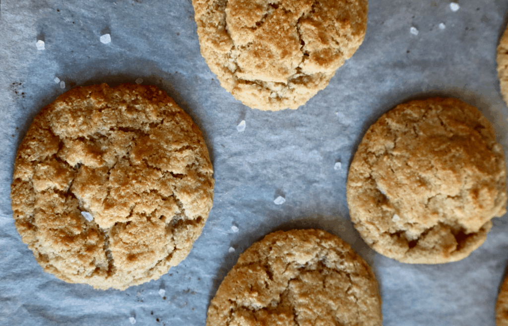 Close-up of golden brown almond flour cookie with crisp edges and soft center.