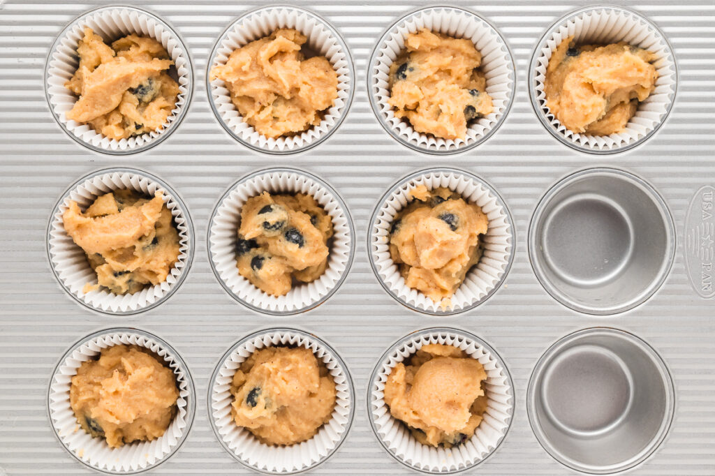 Almond flour muffin batter portioned into a lined 12-cup muffin pan