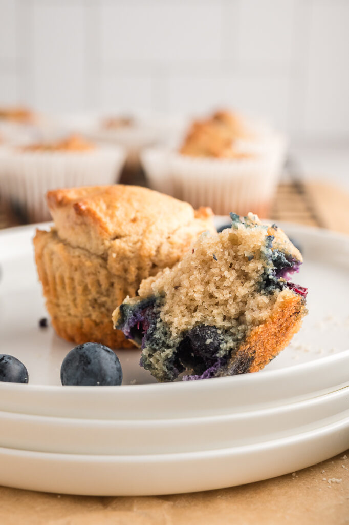 Almond flour blueberry muffin broken open showing soft tender crumb and juicy blueberries inside